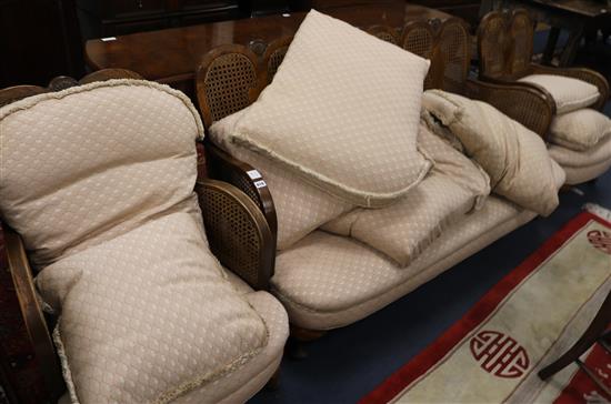 A 1930s walnut single caned three piece bergere suite
